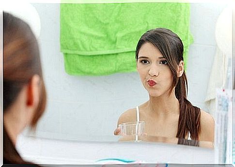 Woman with a glass of mouthwash