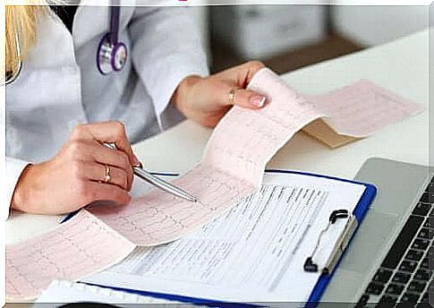 A doctor looks at an EKG printout