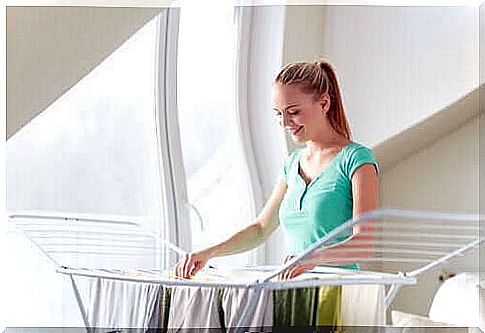 A woman hangs her clothes on the drying rack