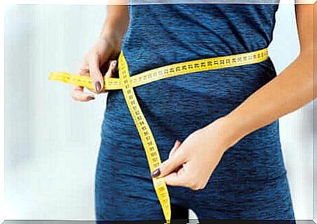 A woman measuring her waist