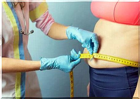 A doctor who measures the waist circumference of a patient